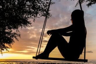 Silhouette of Woman on Swing during Golden Hour