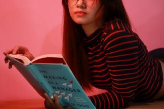 Woman in Striped Long Sleeve Shirt Holding a Book