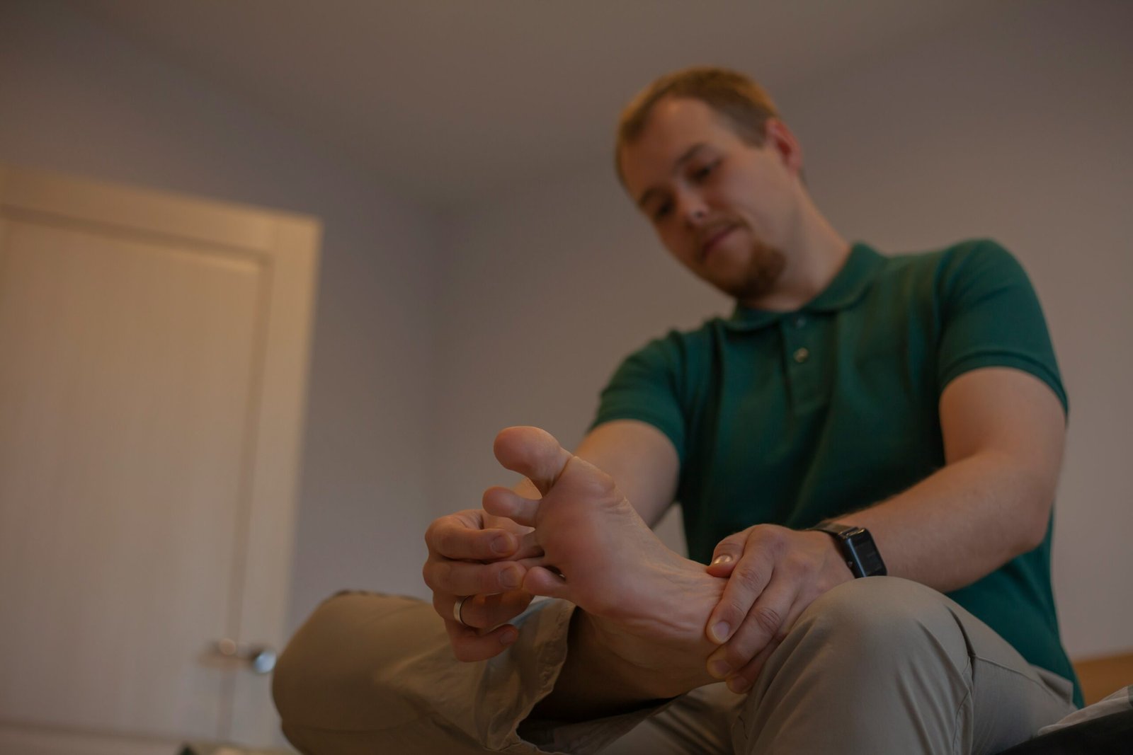 a man sitting on a bed with his feet up