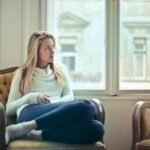 Photography of Woman Sitting on Chair Near Window