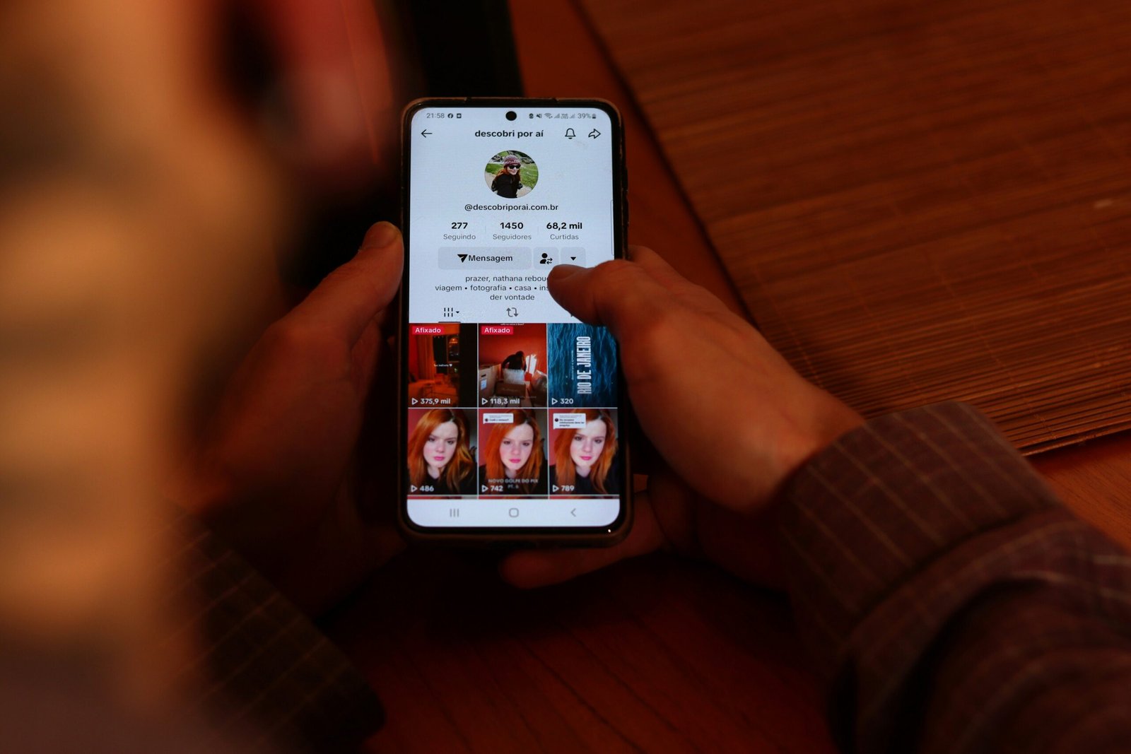 A person holding a cell phone with multiple pictures on the screen